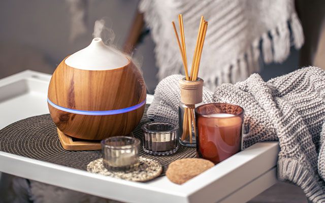 Tablett mit einem Diffuser, Duftstäbchen und Duftkerzen