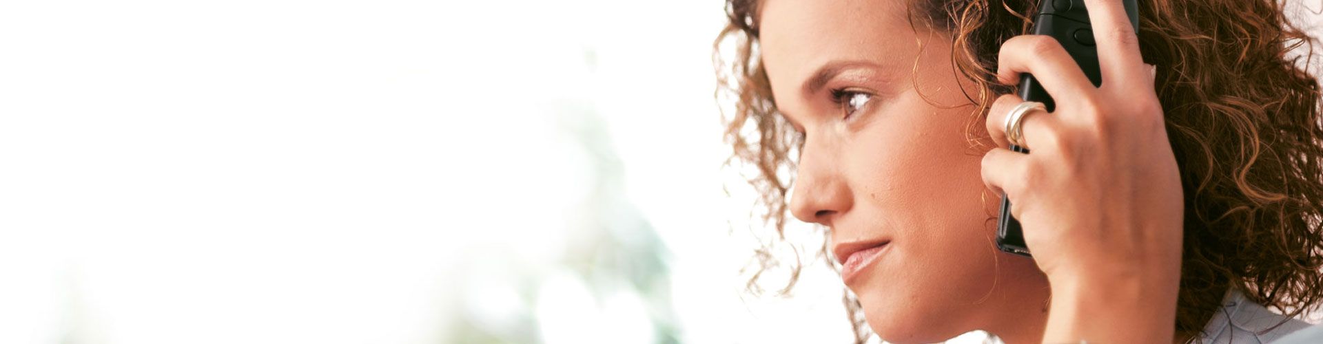 Frau in Profil mit Mobiltelefon am Ohr